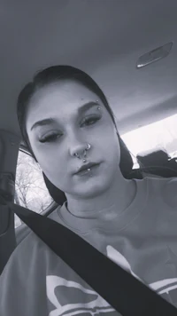 a woman sitting in a car with piercings